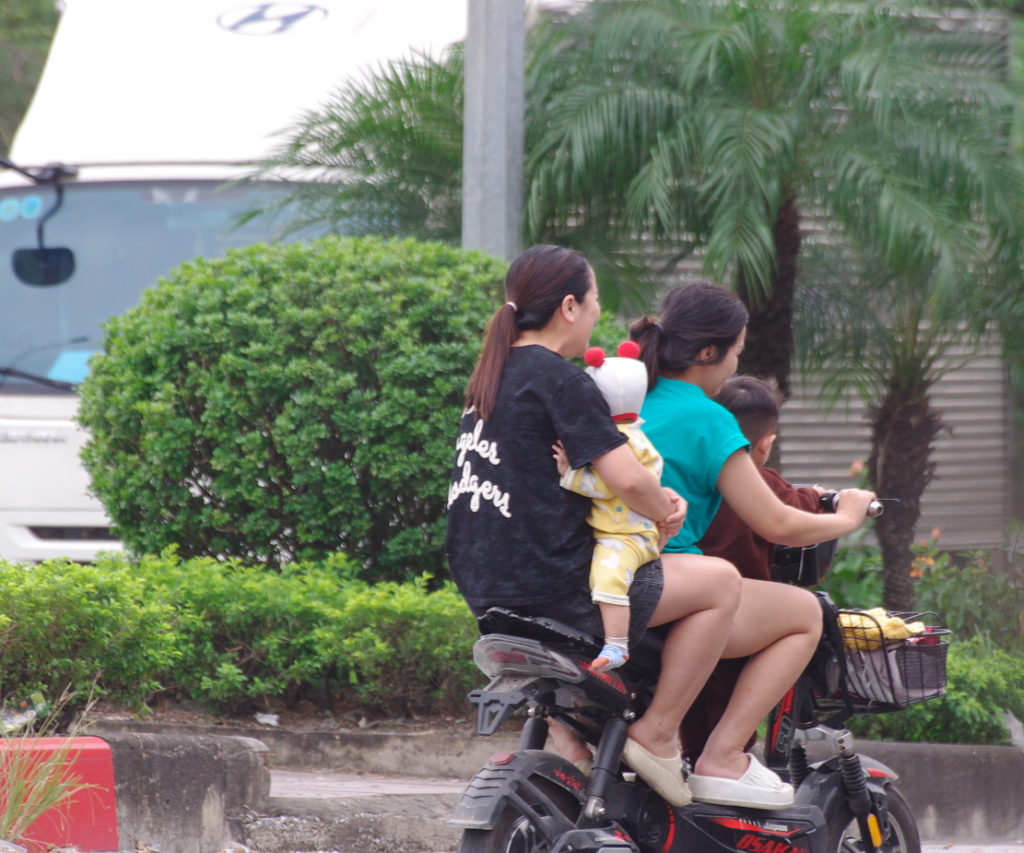 乳児を抱えてバイクに乗る家族