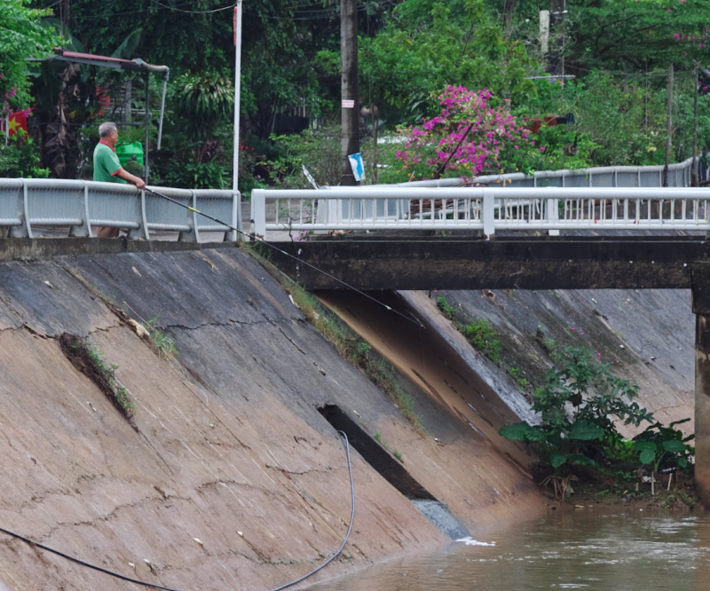 どぶ川で釣りをするおじさん